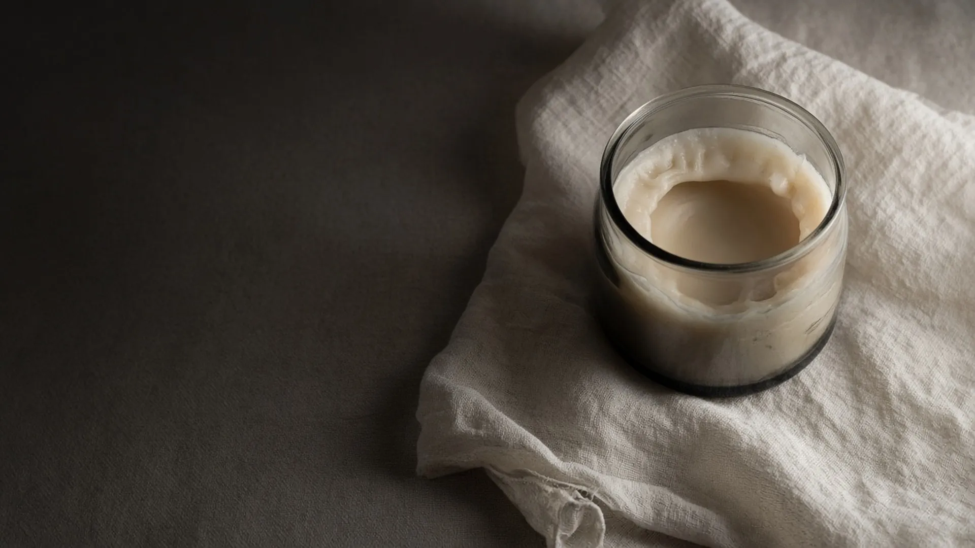 An unlit jar candle seen from above showing a tunnel of wax left on the sides